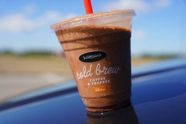 Fond du Lac, Wisconsin USA - Plastik bir fincan Karuba Cold Brew Kahve ve Frappes dışarıda oturuyor.