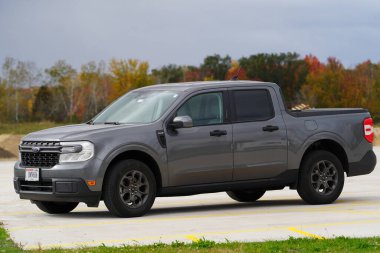 New Lisbon, Wisconsin USA - October 10th, 2024: New grey 2024 Ford Maverick XLT truck sits outside during the fall season. clipart