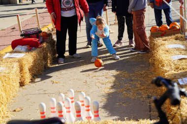 Kunduz Barajı, Wisconsin ABD - 26 Ekim 2024: Cadılar Bayramı kostümlü kız ve erkek çocuklar Sonbahar Festivali 'nde Balkabağı Bowling oynuyorlar.