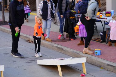 Kunduz Barajı, Wisconsin ABD - 26 Ekim 2024: Sonbahar Festivali 'nde çocuklar ve yeni yürümeye başlayan çocuklar Cadılar Bayramı' nda şeker ya da şeker ödülü almak için Cornhole fasulye torbası oyunu oynadılar.