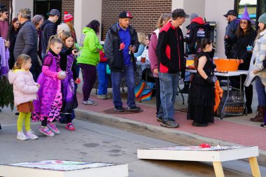 Kunduz Barajı, Wisconsin ABD - 26 Ekim 2024: Sonbahar Festivali 'nde çocuklar ve yeni yürümeye başlayan çocuklar Cadılar Bayramı' nda şeker ya da şeker ödülü almak için Cornhole fasulye torbası oyunu oynadılar.