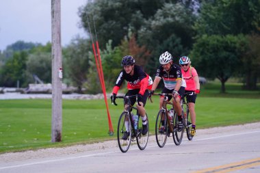 Fond du Lac, Wisconsin USA - 18 Ağustos 2024: Erkek ve kadın bisikletçiler sabahın erken saatlerinde bisiklet sürüyorlar