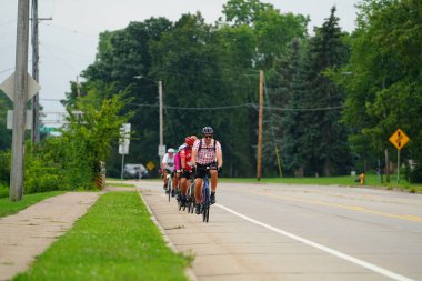 Fond du Lac, Wisconsin USA - 18 Ağustos 2024: Erkek ve kadın bisikletçiler sabahın erken saatlerinde bisiklet sürüyorlar