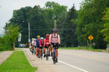 Fond du Lac, Wisconsin USA - 18 Ağustos 2024: Erkek ve kadın bisikletçiler sabahın erken saatlerinde bisiklet sürüyorlar