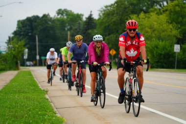 Fond du Lac, Wisconsin USA - 18 Ağustos 2024: Erkek ve kadın bisikletçiler sabahın erken saatlerinde bisiklet sürüyorlar