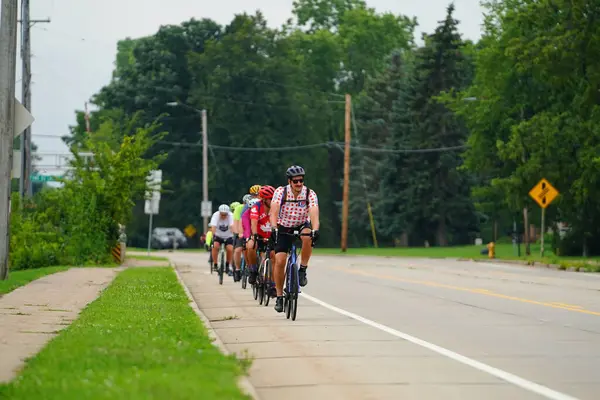 Fond du Lac, Wisconsin USA - 18 Ağustos 2024: Erkek ve kadın bisikletçiler sabahın erken saatlerinde bisiklet sürüyorlar