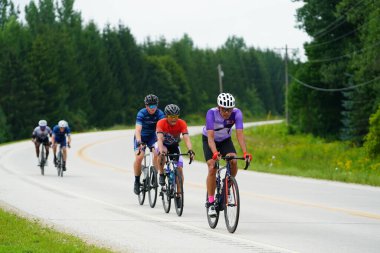 Fond du Lac, Wisconsin USA - 18 Ağustos 2024: Erkek bisikletçiler sabahın erken saatlerinde bisiklet sürüyorlar