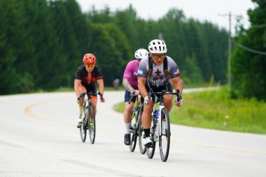 Fond du Lac, Wisconsin USA - 18 Ağustos 2024: Erkek bisikletçiler sabahın erken saatlerinde bisiklet sürüyorlar