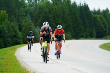 Fond du Lac, Wisconsin USA - 18 Ağustos 2024: Erkek bisikletçiler sabahın erken saatlerinde bisiklet sürüyorlar