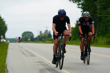 Fond du Lac, Wisconsin USA - 18 Ağustos 2024: Erkek bisikletçiler sabahın erken saatlerinde bisiklet sürüyorlar
