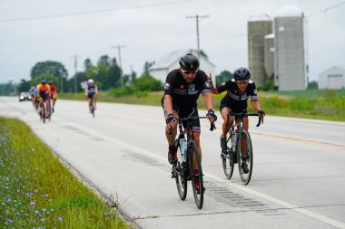 Fond du Lac, Wisconsin USA - 18 Ağustos 2024: Erkek bisikletçiler sabahın erken saatlerinde bisiklet sürüyorlar