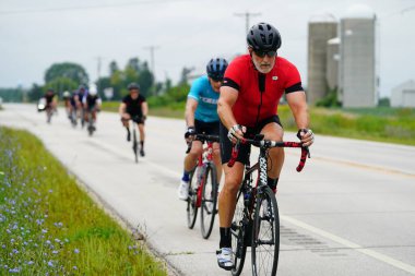 Fond du Lac, Wisconsin USA - 18 Ağustos 2024: Erkek bisikletçiler sabahın erken saatlerinde bisiklet sürüyorlar