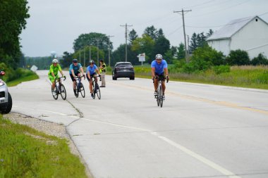 Fond du Lac, Wisconsin USA - 18 Ağustos 2024: Erkek bisikletçiler sabahın erken saatlerinde bisiklet sürüyorlar