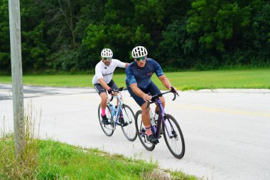 Fond du Lac, Wisconsin USA - 18 Ağustos 2024: Erkek bisikletçiler sabahın erken saatlerinde bisiklet sürüyorlar