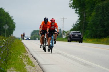 Fond du Lac, Wisconsin USA - 18 Ağustos 2024: Erkek bisikletçiler sabahın erken saatlerinde bisiklet sürüyorlar