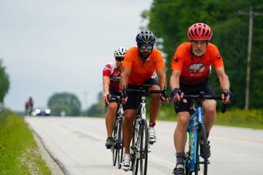 Fond du Lac, Wisconsin USA - 18 Ağustos 2024: Erkek bisikletçiler sabahın erken saatlerinde bisiklet sürüyorlar