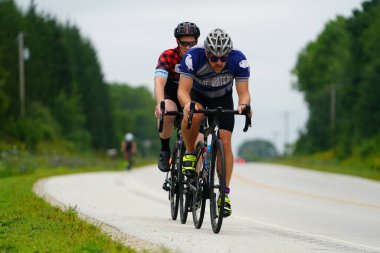 Fond du Lac, Wisconsin USA - 18 Ağustos 2024: Erkek bisikletçiler sabahın erken saatlerinde bisiklet sürüyorlar