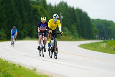 Fond du Lac, Wisconsin USA - 18 Ağustos 2024: Erkek bisikletçiler sabahın erken saatlerinde bisiklet sürüyorlar