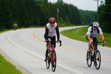 Fond du Lac, Wisconsin USA - 18 Ağustos 2024: Erkek bisikletçiler sabahın erken saatlerinde bisiklet sürüyorlar