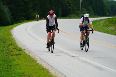 Fond du Lac, Wisconsin USA - 18 Ağustos 2024: Erkek bisikletçiler sabahın erken saatlerinde bisiklet sürüyorlar