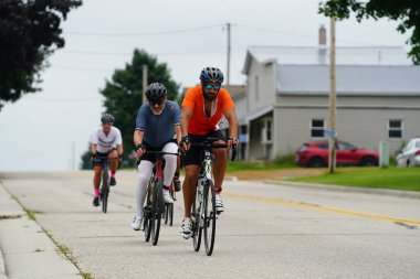 Fond du Lac, Wisconsin USA - 18 Ağustos 2024: Erkek ve kadın bisikletçiler sabahın erken saatlerinde bisiklet sürüyorlar.