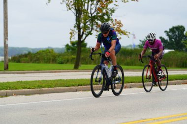 Fond du Lac, Wisconsin USA - 18 Ağustos 2024: Erkek ve kadın bisikletçiler sabahın erken saatlerinde bisiklet sürüyorlar.