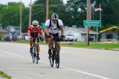 Fond du Lac, Wisconsin USA - 18 Ağustos 2024: Erkek ve kadın bisikletçiler sabahın erken saatlerinde bisiklet sürüyorlar.