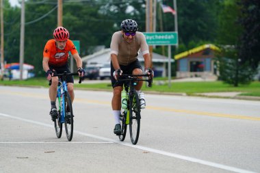 Fond du Lac, Wisconsin USA - 18 Ağustos 2024: Erkek ve kadın bisikletçiler sabahın erken saatlerinde bisiklet sürüyorlar.