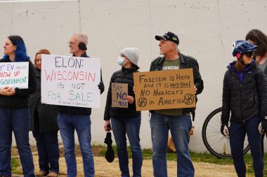 Madison, Wisconsin ABD - 29 Mart 2025: Liberal Demokratlar, Tesla Takedown ulusal etkinliği sırasında Tesla bayilik galerisi önündeki büyük bir gruptaki pankartlarla protesto ettiler.