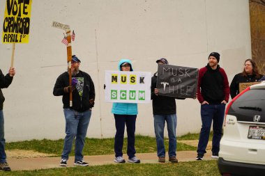 Madison, Wisconsin ABD - 29 Mart 2025: Liberal Demokratlar, Tesla Takedown ulusal etkinliği sırasında Tesla bayilik galerisi önündeki büyük bir gruptaki pankartlarla protesto ettiler.