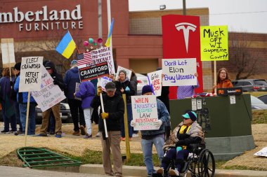 Madison, Wisconsin ABD - 29 Mart 2025: Liberal Demokratlar, Tesla Takedown ulusal etkinliği sırasında Tesla bayilik galerisi önündeki büyük bir gruptaki pankartlarla protesto ettiler.
