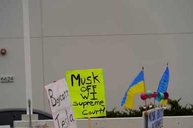 Madison, Wisconsin ABD - 29 Mart 2025: Liberal Demokratlar, Tesla Takedown ulusal etkinliği sırasında Tesla bayilik galerisi önündeki büyük bir gruptaki pankartlarla protesto ettiler.