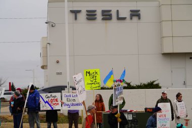 Madison, Wisconsin ABD - 29 Mart 2025: Liberal Demokratlar, Tesla Takedown ulusal etkinliği sırasında Tesla bayilik galerisi önündeki büyük bir gruptaki pankartlarla protesto ettiler.