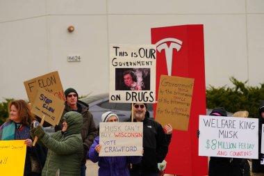 Madison, Wisconsin ABD - 29 Mart 2025: Liberal Demokratlar, Tesla Takedown ulusal etkinliği sırasında Tesla bayilik galerisi önündeki büyük bir gruptaki pankartlarla protesto ettiler.