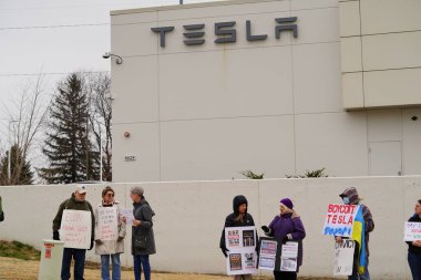 Madison, Wisconsin ABD - 29 Mart 2025: Liberal Demokratlar, Tesla Takedown ulusal etkinliği sırasında Tesla bayilik galerisi önündeki büyük bir gruptaki pankartlarla protesto ettiler.