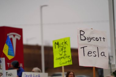 Madison, Wisconsin ABD - 29 Mart 2025: Liberal Demokratlar, Tesla Takedown ulusal etkinliği sırasında Tesla bayilik galerisi önündeki büyük bir gruptaki pankartlarla protesto ettiler.