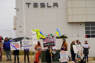 Madison, Wisconsin ABD - 29 Mart 2025: Liberal Demokratlar, Tesla Takedown ulusal etkinliği sırasında Tesla bayilik galerisi önündeki büyük bir gruptaki pankartlarla protesto ettiler.