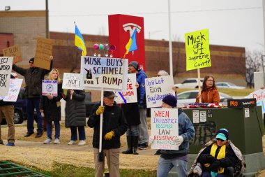 Madison, Wisconsin ABD - 29 Mart 2025: Liberal Demokratlar, Tesla Takedown ulusal etkinliği sırasında Tesla bayilik galerisi önündeki büyük bir gruptaki pankartlarla protesto ettiler.