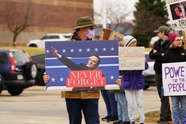 Madison, Wisconsin ABD - 29 Mart 2025: Liberal Demokratlar, Tesla Takedown ulusal etkinliği sırasında Tesla bayilik galerisi önündeki büyük bir gruptaki pankartlarla protesto ettiler.