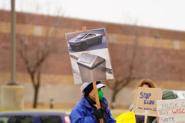 Madison, Wisconsin ABD - 29 Mart 2025: Liberal Demokratlar, Tesla Takedown ulusal etkinliği sırasında Tesla bayilik galerisi önündeki büyük bir gruptaki pankartlarla protesto ettiler.