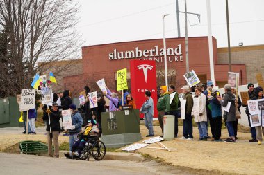 Madison, Wisconsin ABD - 29 Mart 2025: Liberal Demokratlar, Tesla Takedown ulusal etkinliği sırasında Tesla bayilik galerisi önündeki büyük bir gruptaki pankartlarla protesto ettiler.
