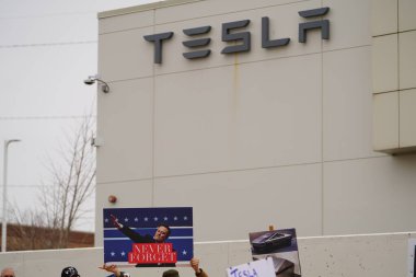 Madison, Wisconsin ABD - 29 Mart 2025: Liberal Demokratlar, Tesla Takedown ulusal etkinliği sırasında Tesla bayilik galerisi önündeki büyük bir gruptaki pankartlarla protesto ettiler.