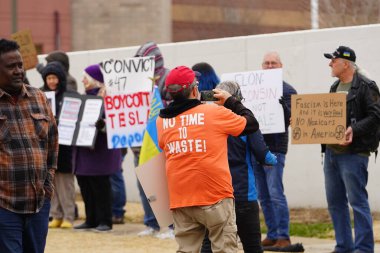 Madison, Wisconsin ABD - 29 Mart 2025: Liberal Demokratlar, Tesla Takedown ulusal etkinliği sırasında Tesla bayilik galerisi önündeki büyük bir gruptaki pankartlarla protesto ettiler.