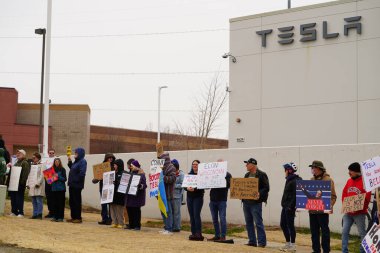 Madison, Wisconsin ABD - 29 Mart 2025: Liberal Demokratlar, Tesla Takedown ulusal etkinliği sırasında Tesla bayilik galerisi önündeki büyük bir gruptaki pankartlarla protesto ettiler.