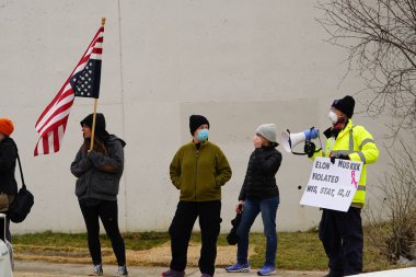 Madison, Wisconsin ABD - 29 Mart 2025: Liberal Demokratlar, Tesla Takedown ulusal etkinliği sırasında Tesla bayilik galerisi önündeki büyük bir gruptaki pankartlarla protesto ettiler.