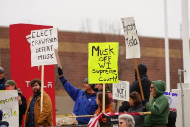Madison, Wisconsin ABD - 29 Mart 2025: Liberal Demokratlar, Tesla Takedown ulusal etkinliği sırasında Tesla bayilik galerisi önündeki büyük bir gruptaki pankartlarla protesto ettiler.