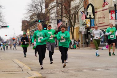 Fond du Lac, Wisconsin ABD - 15 Mart 2025: Cemaat üyeleri ve Yerel Örgütler 2025 St. Patrick Günü Yürüyüşüne katıldı ve çocuklara şeker dağıtarak sokaklarda dolaştı.
