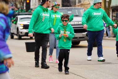 Fond du Lac, Wisconsin ABD - 15 Mart 2025: Cemaat üyeleri ve Yerel Örgütler 2025 St. Patrick Günü Yürüyüşüne katıldı ve çocuklara şeker dağıtarak sokaklarda dolaştı.