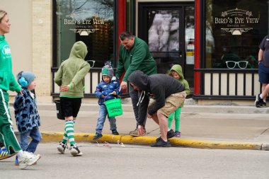 Fond du Lac, Wisconsin ABD - 15 Mart 2025: Cemaat üyeleri ve Yerel Örgütler 2025 St. Patrick Günü Yürüyüşüne katıldı ve çocuklara şeker dağıtarak sokaklarda dolaştı.