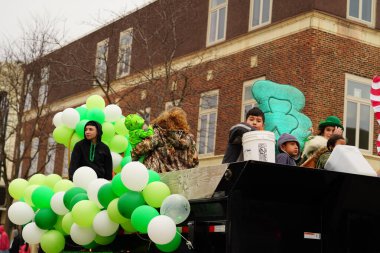 Fond du Lac, Wisconsin ABD - 15 Mart 2025: Cemaat üyeleri ve Yerel Örgütler 2025 St. Patrick Günü Yürüyüşüne katıldı ve çocuklara şeker dağıtarak sokaklarda dolaştı.